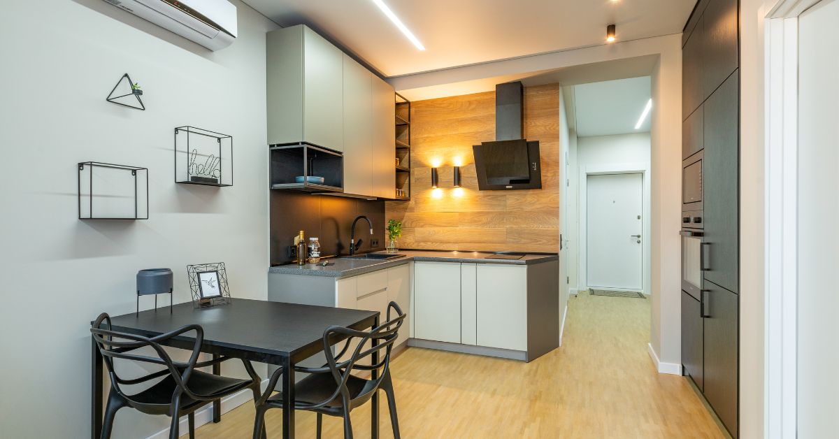 owoczesna kuchnia z jasnymi frontami, drewnianym blatem, czarnym okapem i dekoracyjnymi półkami